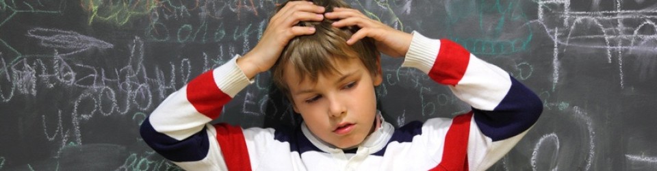 pupil standing near school board and hold on his head half body sad face